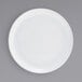 A close-up of a Front of the House Harmony bright white porcelain plate with a white rim.