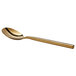 An Acopa Phoenix stainless steel bouillon spoon with a gold handle.