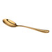 A gold-colored, shiny metal spoon with a gently curved handle, shown on a white background.