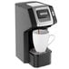 A Hamilton Beach black single-serve coffee maker with a white cup and black handle on top.