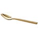 An Acopa Phoenix gold stainless steel teaspoon with a long handle.