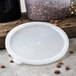The white plastic lid for a Carlisle round food storage container.