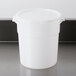 A white plastic Carlisle food storage container with a lid on a counter.