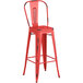 A red metal Lancaster Table & Seating outdoor cafe barstool with a black back.