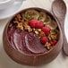 A bowl of Acai Roots organic acai sorbet topped with raspberries, bananas, and nuts.