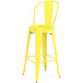 A yellow metal Lancaster Table & Seating outdoor cafe barstool with a backrest.