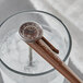 A brown AvaTemp probe thermometer in a glass of water.