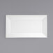A white rectangular porcelain platter with a white border on a gray surface.