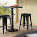 Lancaster Table & Seating Alloy Series Black Stackable Metal Indoor / Outdoor Industrial Cafe Counter Height Stool with Drain Hole Seat Main Thumbnail 1