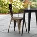 A Lancaster Table & Seating black metal chair and table on an outdoor patio.