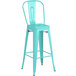 A seafoam blue Lancaster Table & Seating outdoor cafe barstool with a metal back.