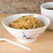 A blue Thunder Group Blue Bamboo melamine rice bowl filled with rice and vegetables on a table with a cup of tea.