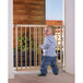 A baby standing in front of a Beechwood extending safety gate.