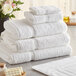 A stack of white Lavex Premium bath towels on a table.