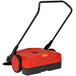 A red and black Bissell Commercial outdoor power sweeper with a handle.