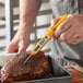A person using a CDN DTT450 ProAccurate digital pocket probe thermometer to check the temperature of meat.