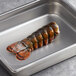A metal pan filled with 6-7 oz. Boston Lobster Company lobster tails.