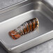 A large stainless steel pan with Boston Lobster Company 3-4 oz. lobster tails inside.