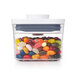 An OXO Good Grips rectangular plastic food storage container with a white lid filled with jelly beans.