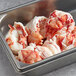 A metal container filled with Boston Lobster Company fresh lobster tail meat.