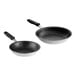 Two Vollrath stainless steel frying pans with black silicone handles.
