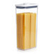 A OXO Good Grips rectangular plastic food storage container with pasta inside and a white lid.