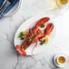 A lobster on a plate with a fork and knife.