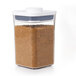 An OXO Good Grips square plastic food storage container with a white lid holding brown sugar.