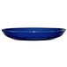 A cobalt blue International Tableware stoneware saucer on a white surface.