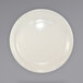 A close up of an International Tableware Valencia ivory stoneware plate with a narrow rim on a white surface.