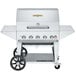 A silver stainless steel Crown Verity mobile barbecue grill with wheels and a lid.