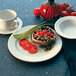 An International Tableware Newport ivory stoneware plate with food and a cup of coffee.