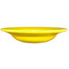 A close up of a yellow International Tableware stoneware deep rim soup bowl.