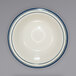 An ivory stoneware grapefruit bowl with blue bands on the rim.