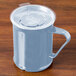 A Cambro slate blue polycarbonate mug with a handle on a wooden table.