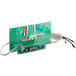 A green circuit board with wires and a power cord.