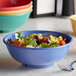 A bowl of salad with tomatoes and lettuce in an Elite Global Solutions Brazil melamine bowl with a fork.