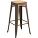 A Lancaster Table & Seating copper bar stool with a natural wood seat.