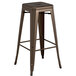 A Lancaster Table & Seating copper backless barstool with a natural wood seat.