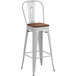 A white metal bar stool with a walnut seat.
