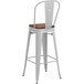 A white Lancaster Table & Seating barstool with a walnut seat.