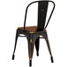 A black metal Lancaster Table & Seating cafe chair with a walnut wood seat.