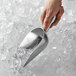 A person using a Vollrath cast aluminum ice scoop to scoop ice.