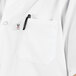 A close up of the pocket of a white Uncommon Chef cook shirt with a pen in it.