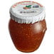 A jar of Dalmatia Fig Spread with Fresh Orange and a white lid on a table.