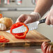 A person using a Wusthof Classic Craftsman Cook's Knife to cut a tomato.