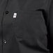A close-up of a black Uncommon Chef cook shirt with a white pocket.