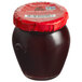 A Dalmatia jar of Sour Cherry Spread with a red lid.