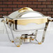 A stainless steel water pan for a silver chafer with gold trim.