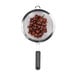 A OXO stainless steel mesh strainer with black handle full of grapes.